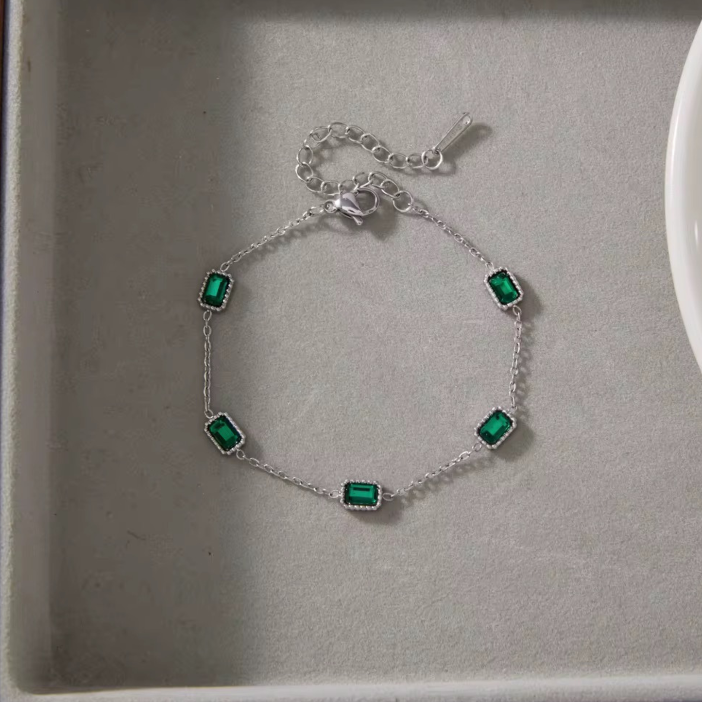 Emerald Muse Bracelet crafted from stainless steel with 18K gold plating and emerald-inspired crystals, designed for elegant everyday wear.