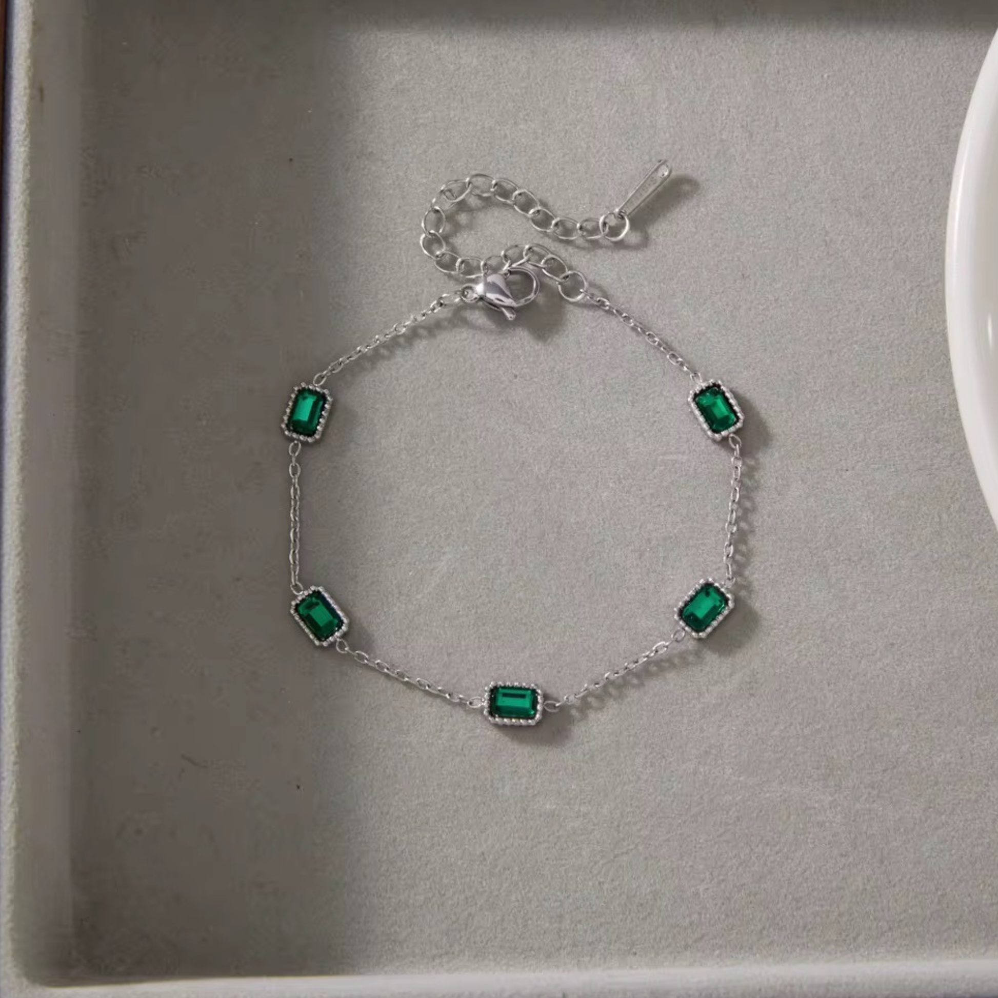 Emerald Muse Bracelet crafted from stainless steel with 18K gold plating and emerald-inspired crystals, designed for elegant everyday wear.